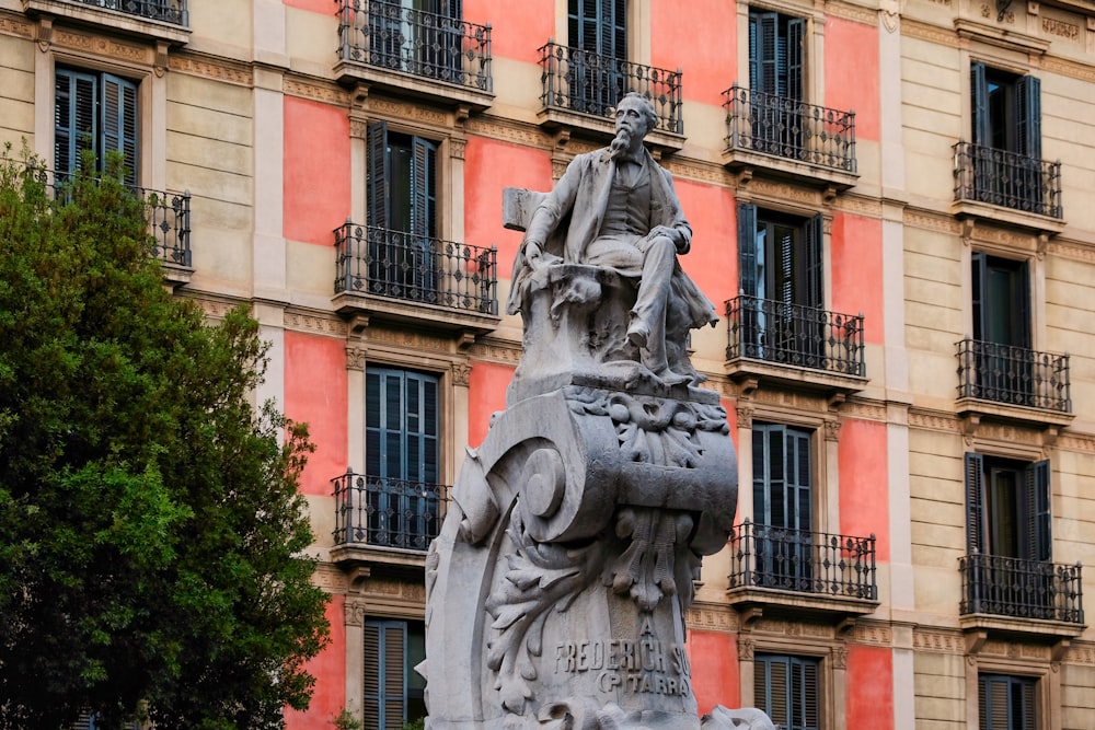 Estatua de hormigón gris cerca de un edificio de hormigón marrón durante el día