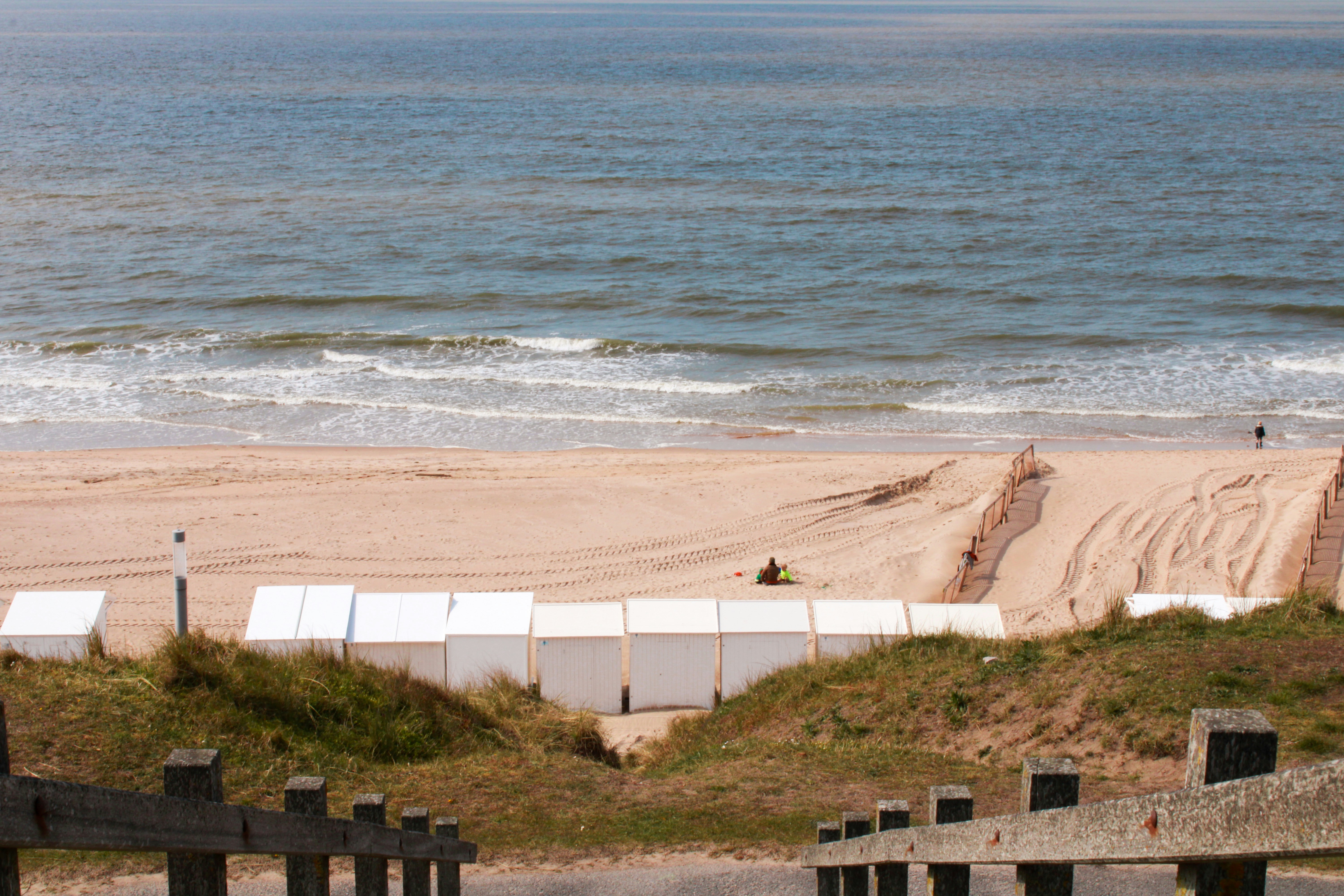 white concrete fence near body of water during daytime