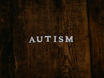 Photo of a thoughtful person surrounded by puzzle pieces symbolizing autism spectrum.