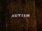 The word 'AUTISM' is centered on a rustic, dark wooden background. The texture of the wood is rough and weathered, adding a natural and organic feel to the image.