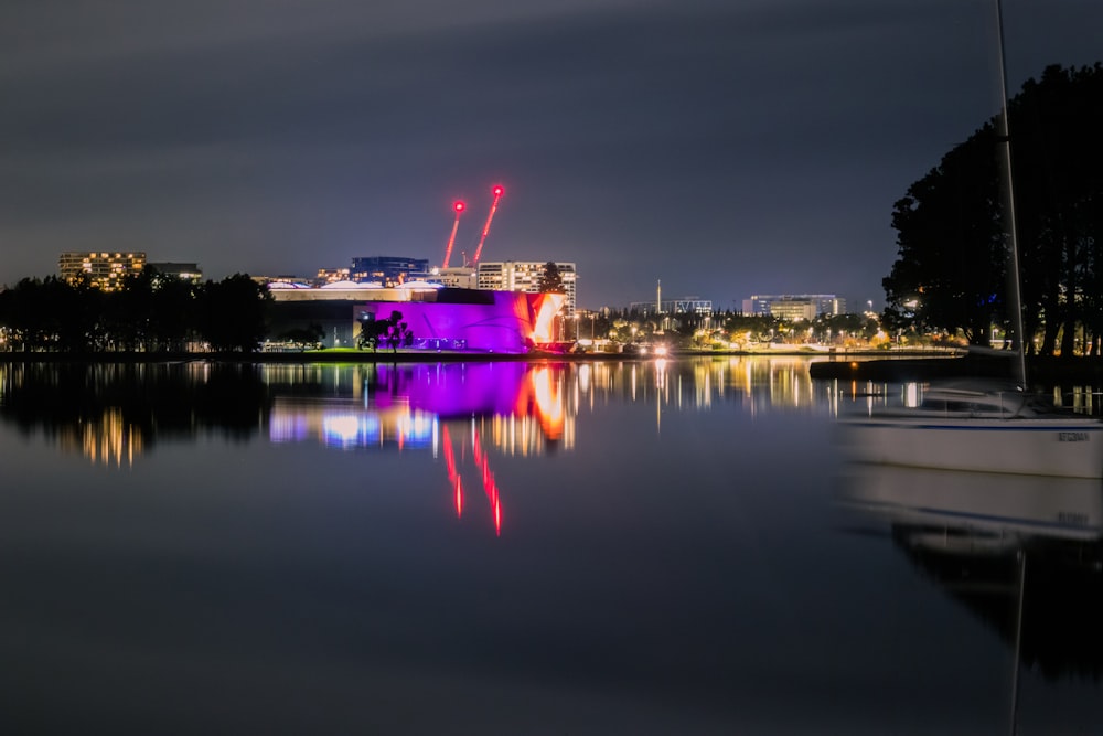 body of water near city buildings during night time