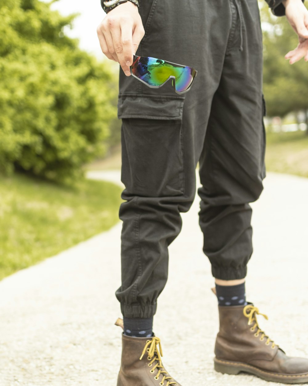 man in black jacket and blue denim jeans walking on street during daytime