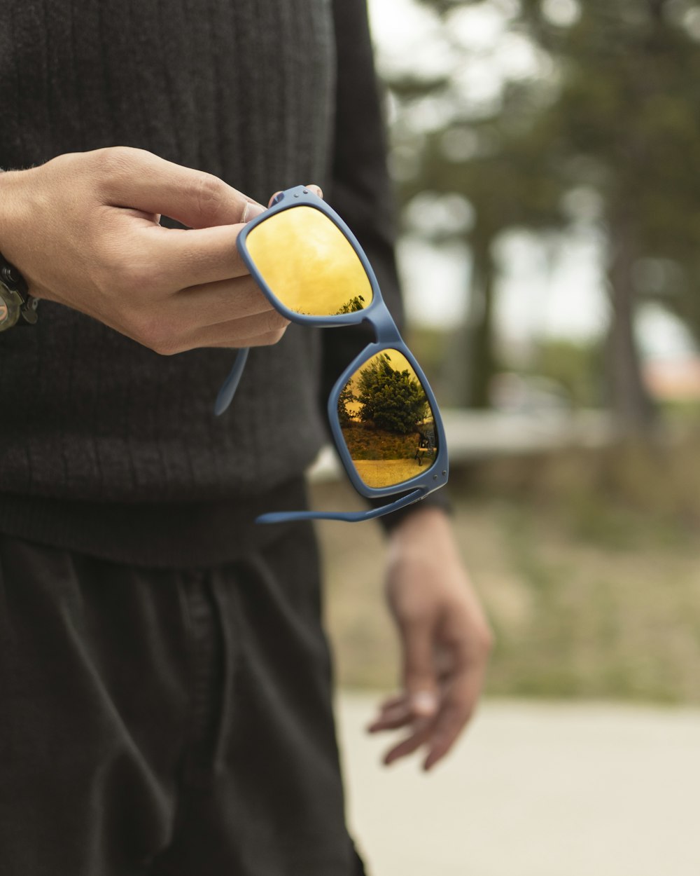 person in black long sleeve shirt wearing yellow framed sunglasses