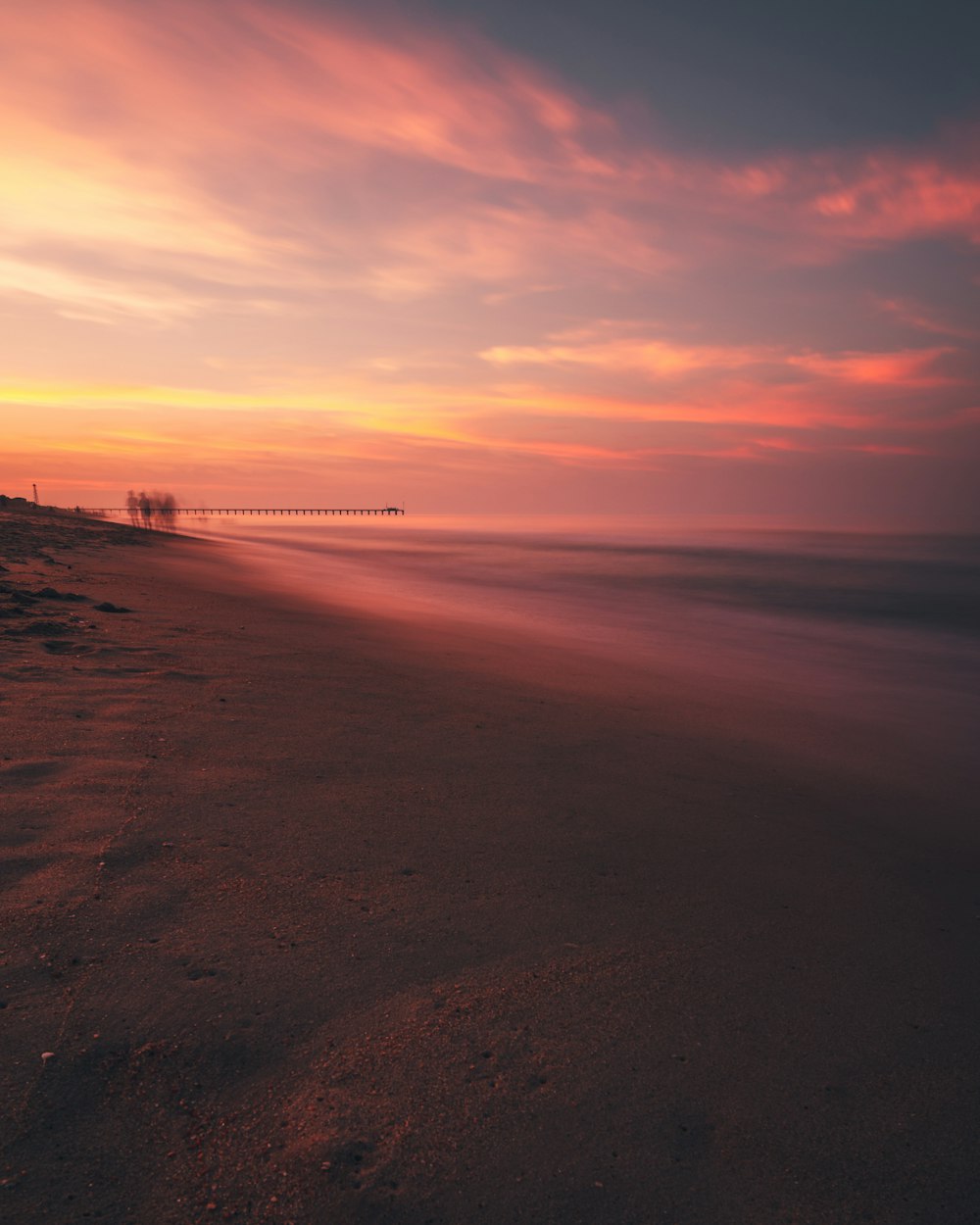 Menschen, die während des Sonnenuntergangs am Strand spazieren gehen