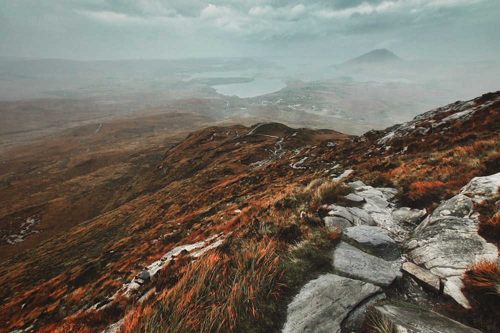 brown and green mountains under white clouds during daytime