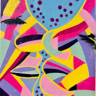 A vibrant street mural full of colorful abstract shapes and lively characters.