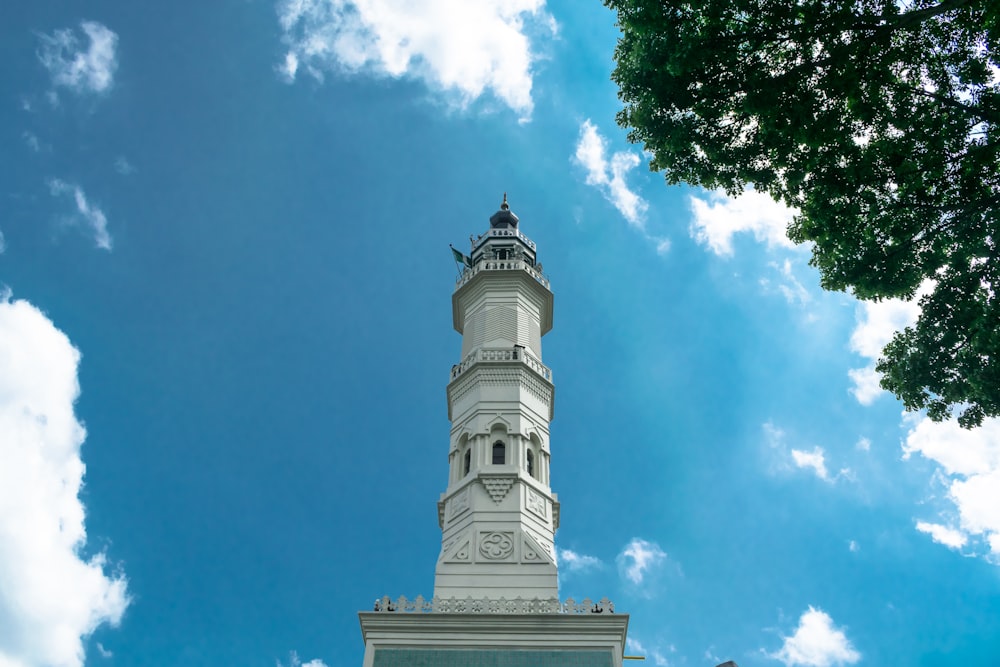 Weißer Betonturm unter blauem Himmel und weißen Wolken tagsüber