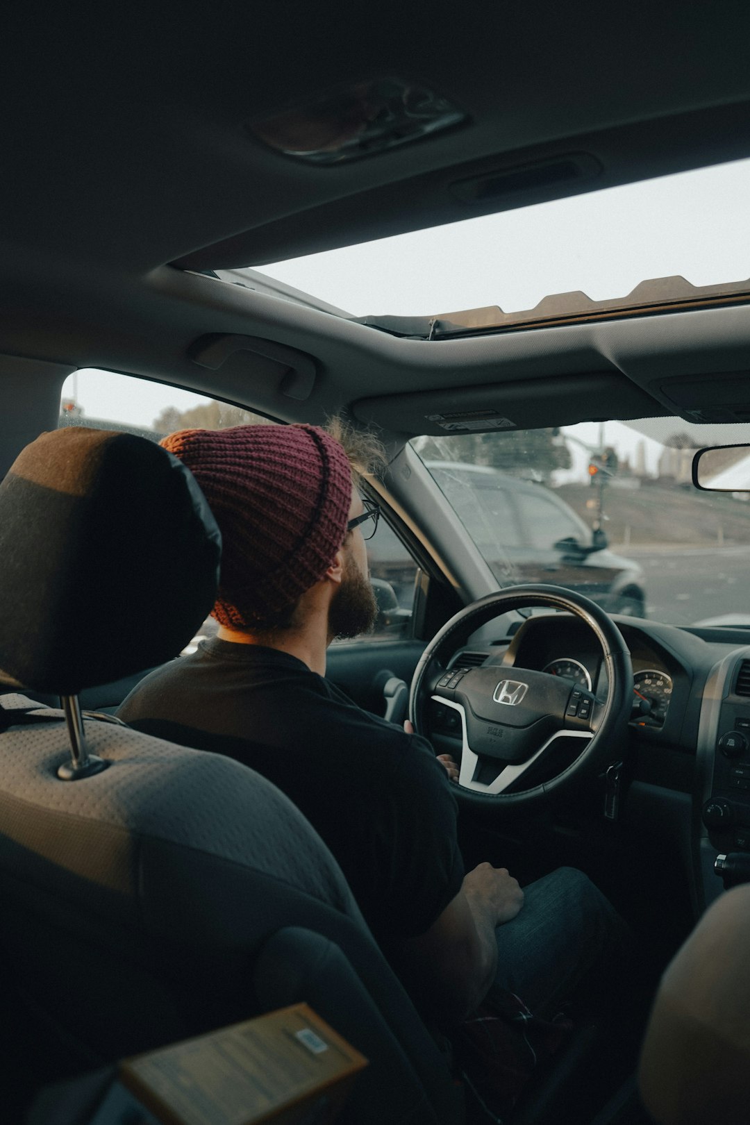 man in black jacket driving car