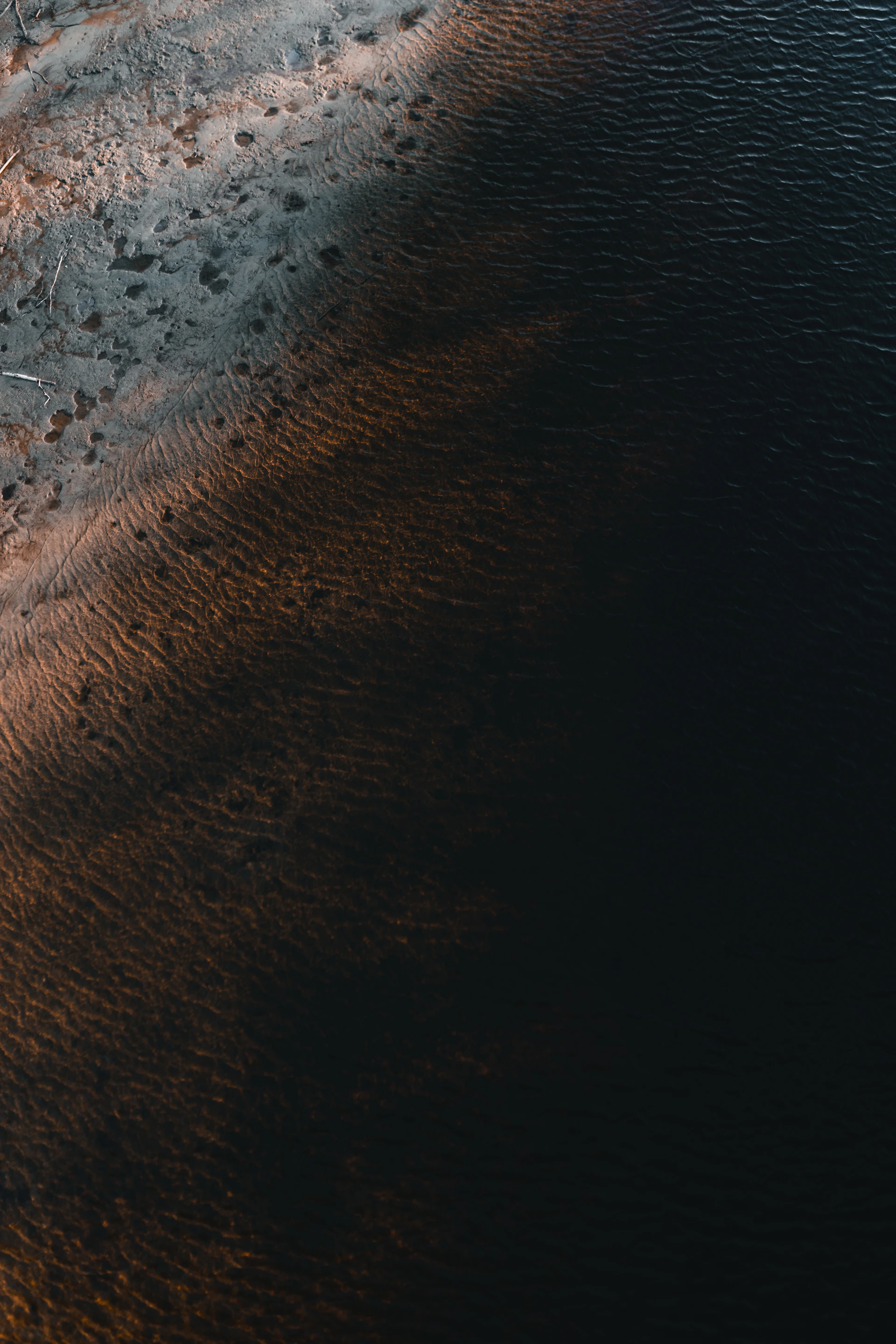 brown sand near body of water during daytime