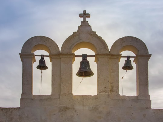 brown bell on white concrete wall in Comino Malta