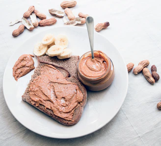 A cozy scene featuring creamy peanut butter spread on warm bread with tropical fruit slices nearby.