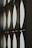 A series of panels with curved cutouts, allowing light to pass through and create patterns. The panels are arranged vertically and appear to be part of an architectural structure, possibly windows or screens, with a play of light and shadow.