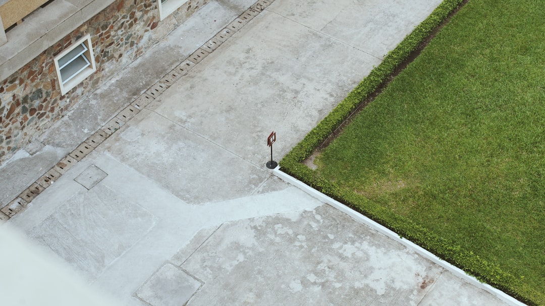 person in red shirt walking on gray concrete pavement