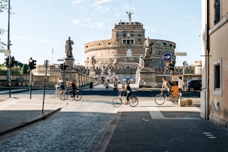 people riding bicycle on road near concrete building during daytime