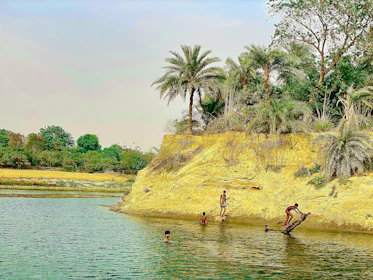 Young students learning about tropical ecology outdoors near a riverbank.