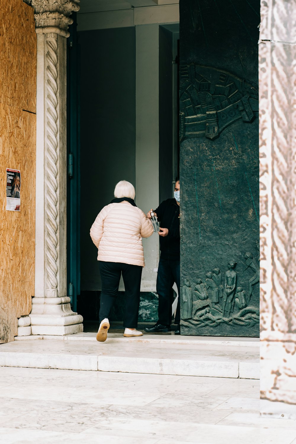 man in white and black striped long sleeve shirt and black pants standing beside black wooden