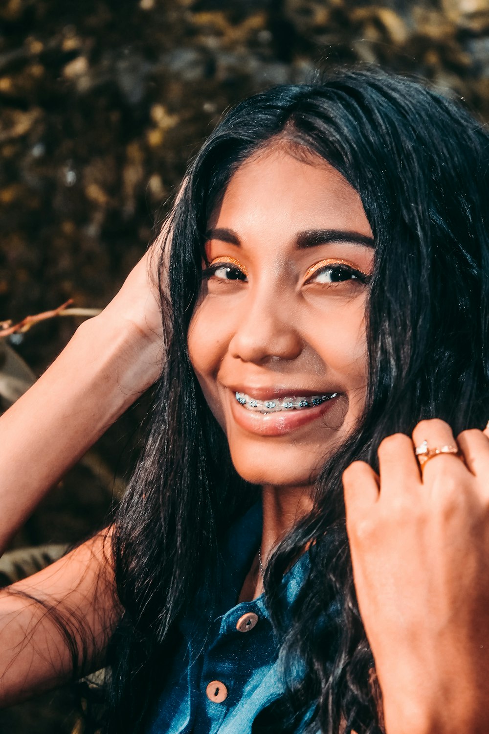 woman in blue sleeveless top smiling