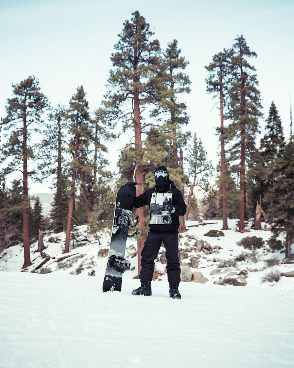 man in black jacket and black pants standing on snow covered ground during daytime