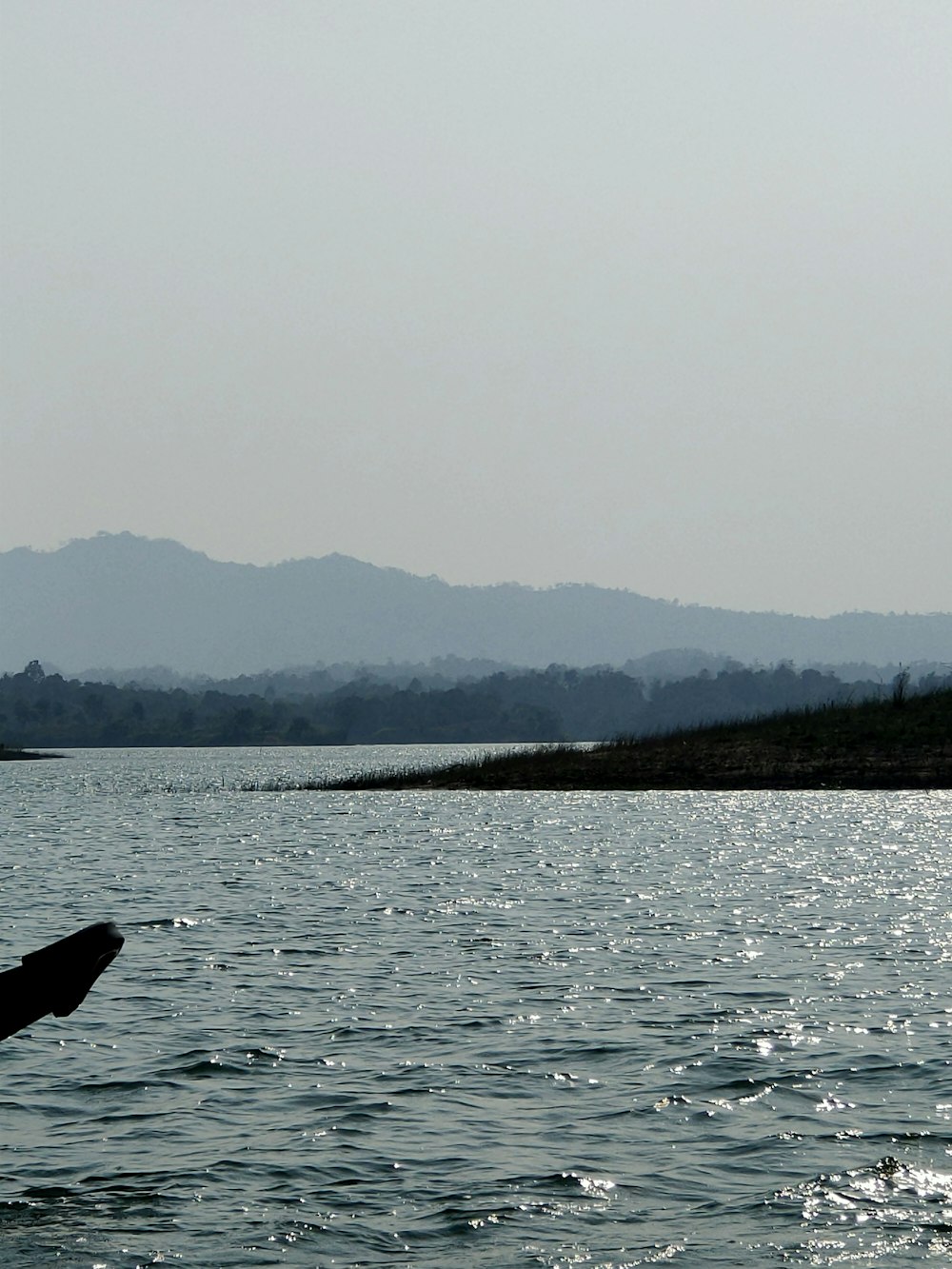 body of water near mountain during daytime