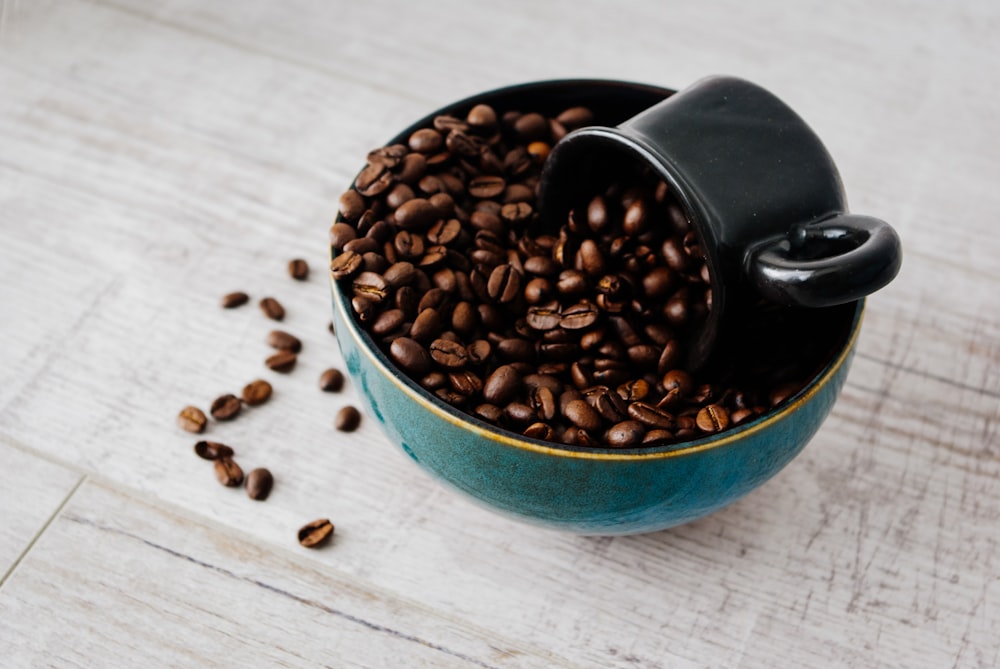 black coffee beans in green ceramic mug