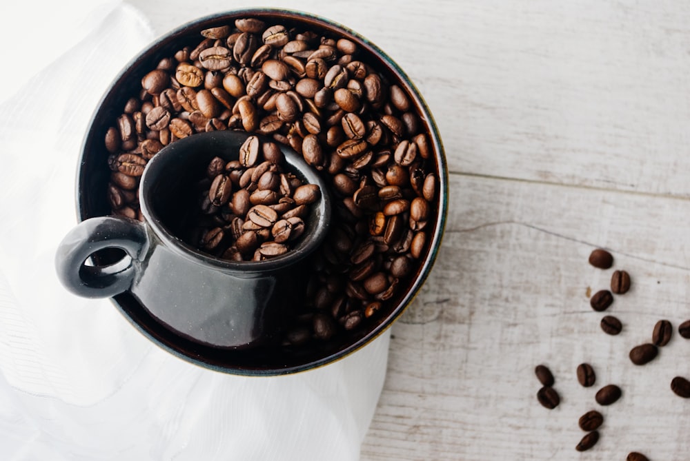 coffee beans in black ceramic mug