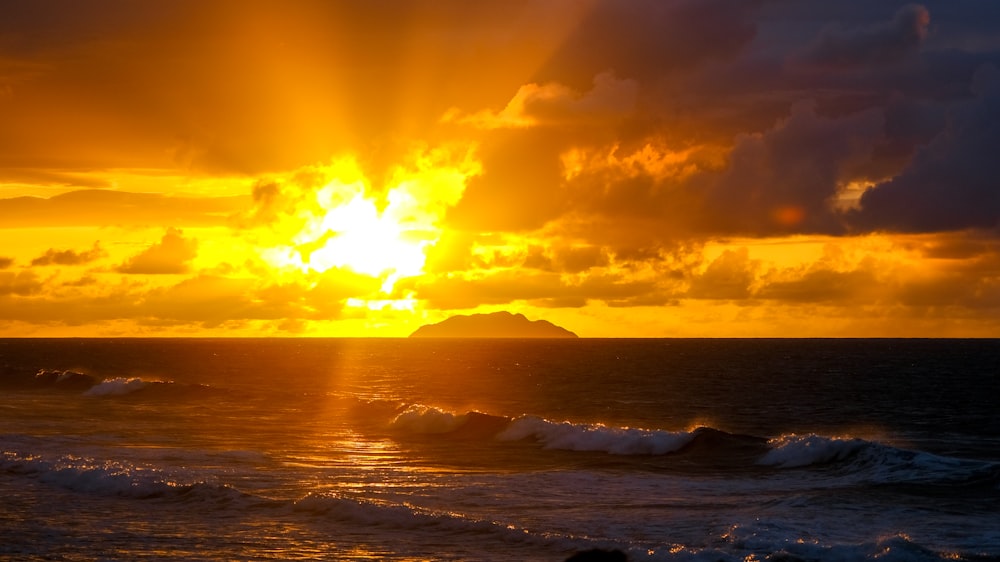 ocean waves crashing on shore during sunset