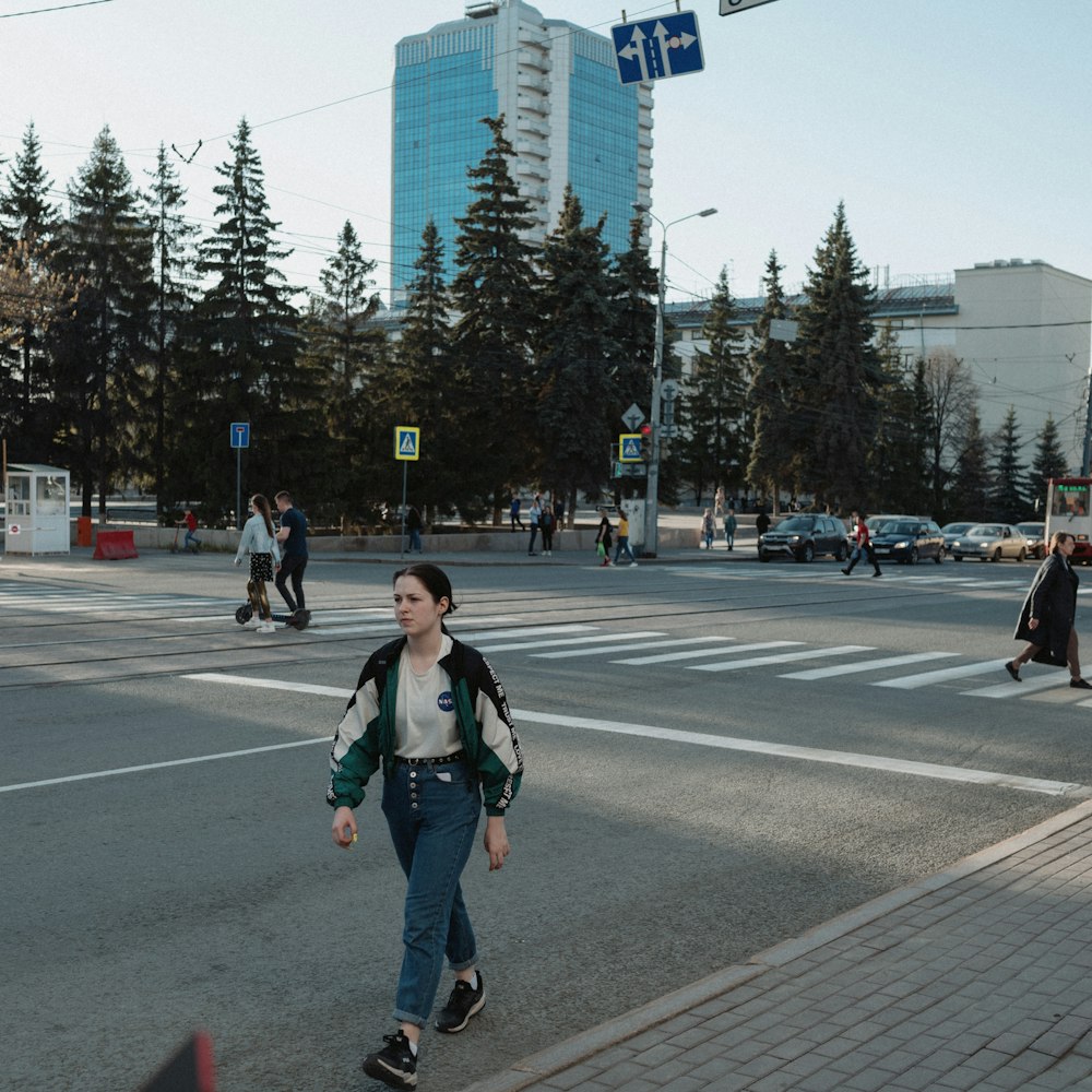 woman in black jacket and black pants walking on pedestrian lane during daytime