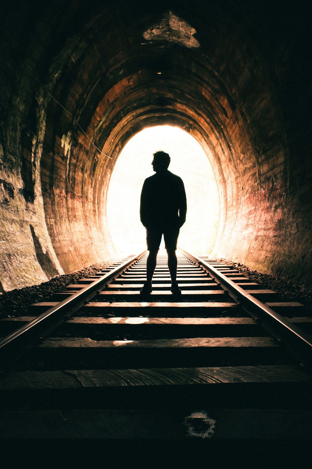 silhouette of person walking on tunnel