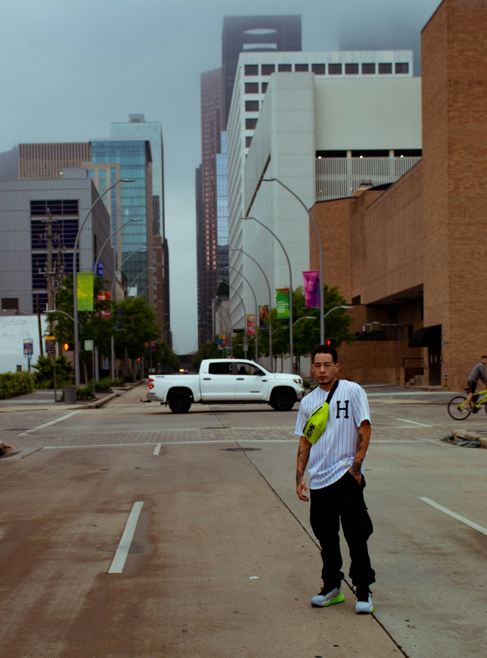 man in white shirt and black pants walking on sidewalk during daytime