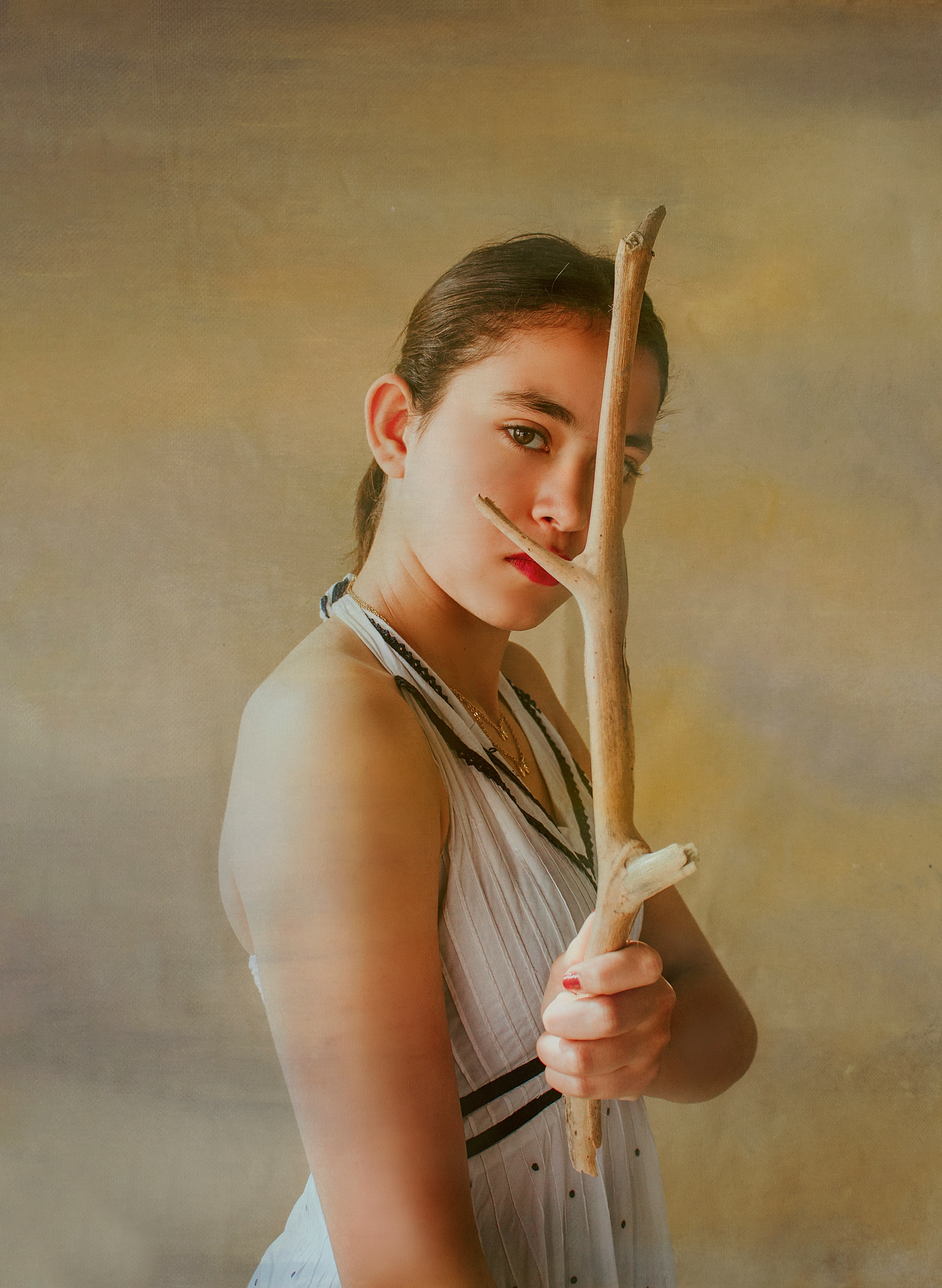 woman in white tank top holding brown stick