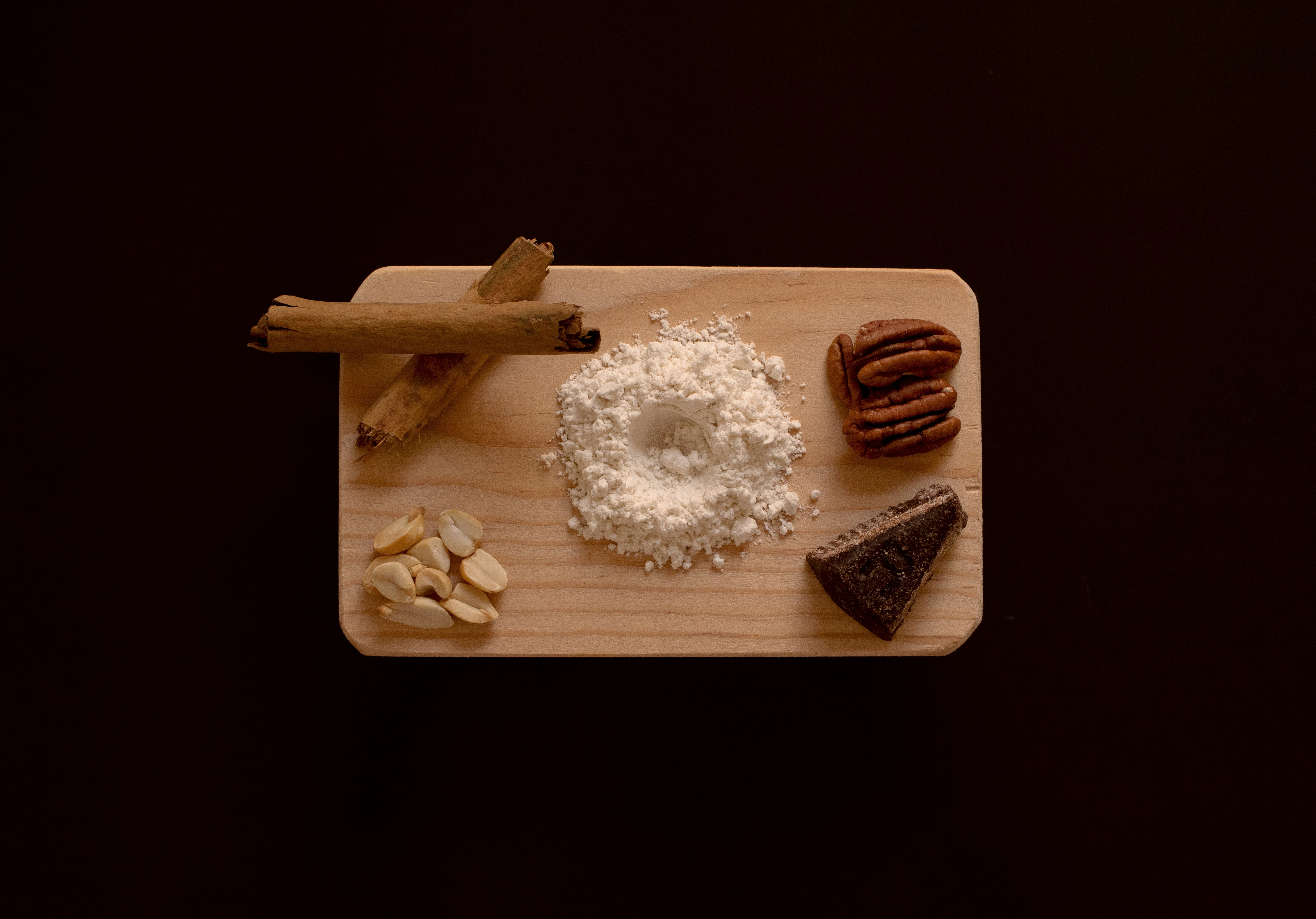 white and brown doughnut on brown wooden chopping board