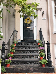 A sturdy storm door with black trim protecting a colorful orange house entrance.