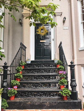 A sturdy storm door with black trim protecting a colorful orange house entrance.