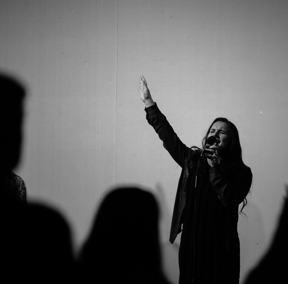 woman in black coat standing in front of people