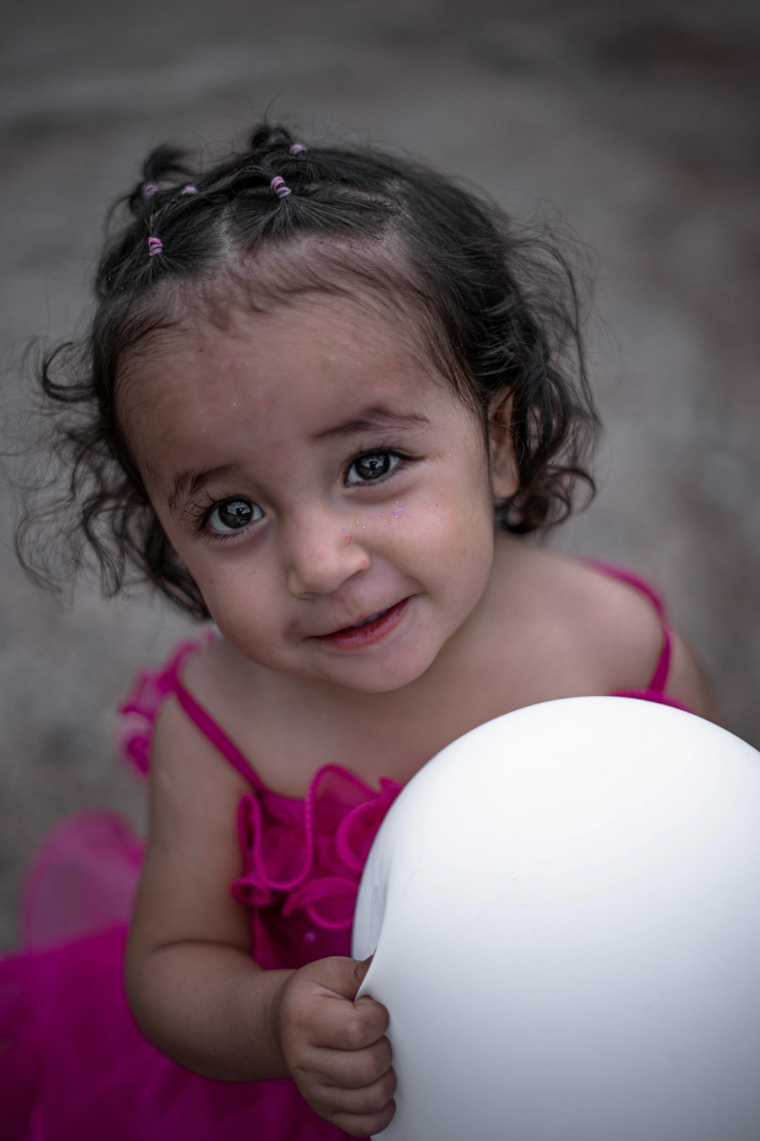 girl in pink tank top holding white ball