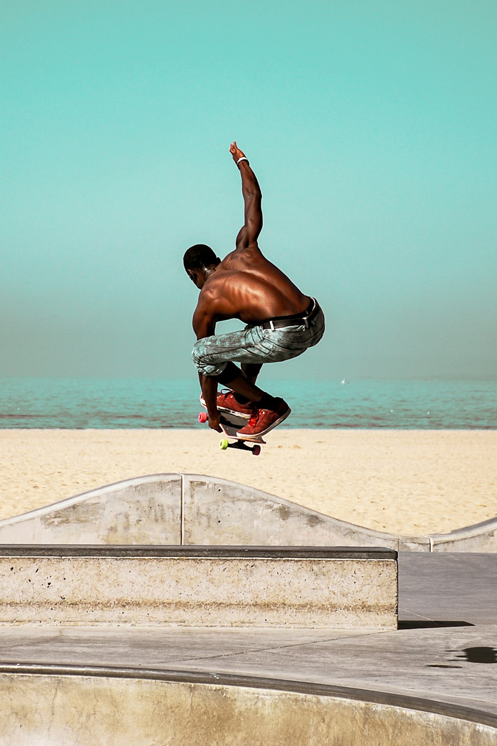 man in gray shorts doing yoga on white concrete railings near body of water during daytime