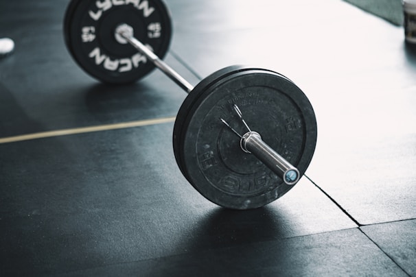 A professional barbell resting on a sleek gym rack ready for lifting