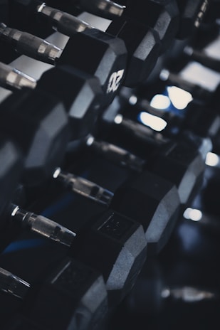 A close-up of weights and gym accessories on a dark background.