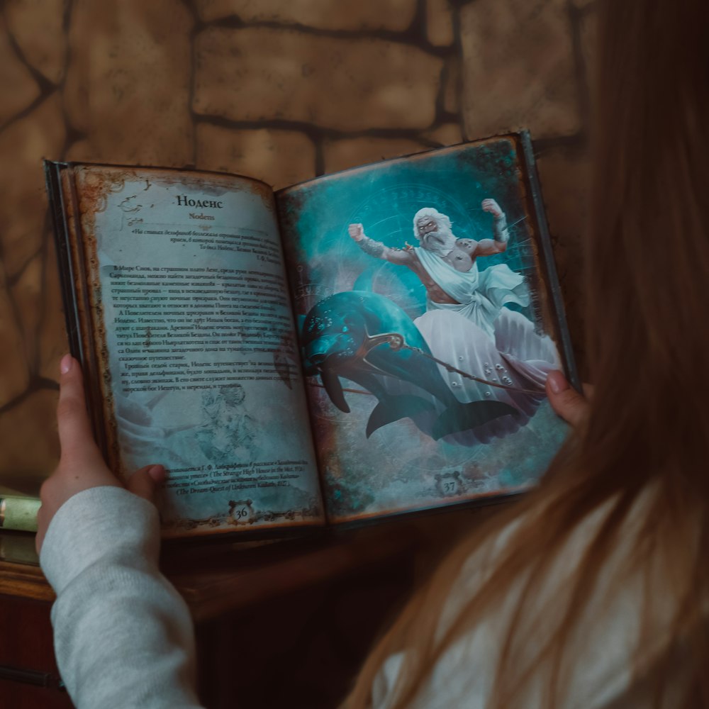 person holding book on brown textile