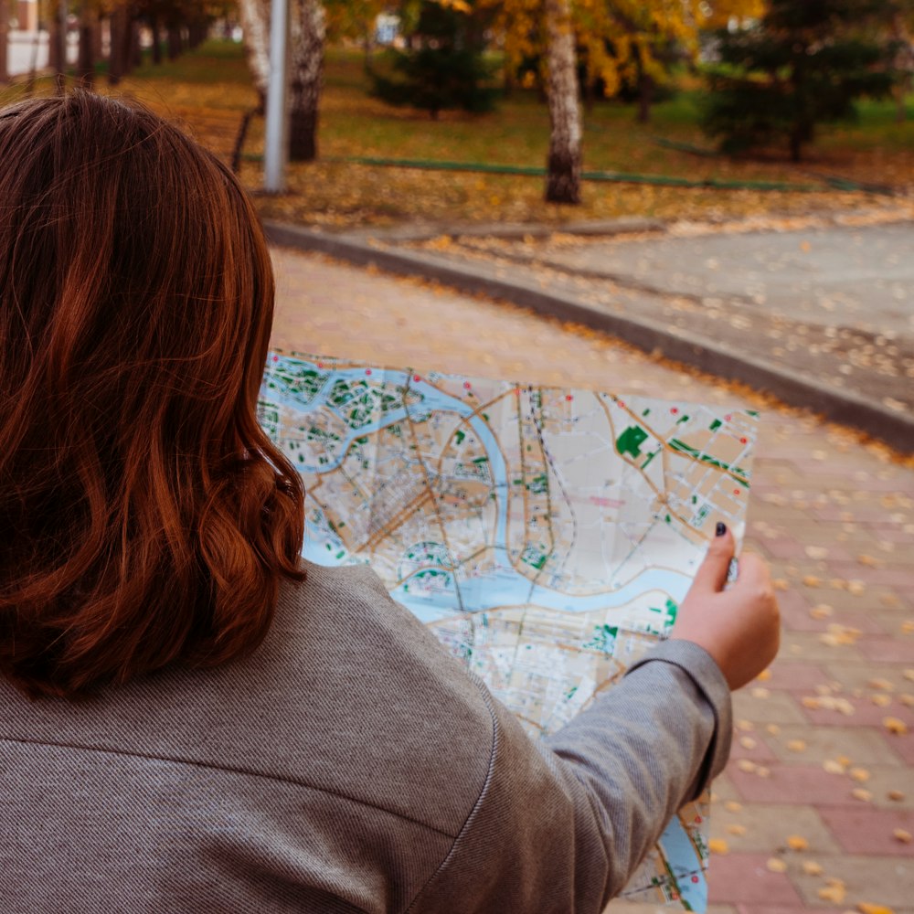 woman in gray jacket playing with blue and white paint on the street during daytime