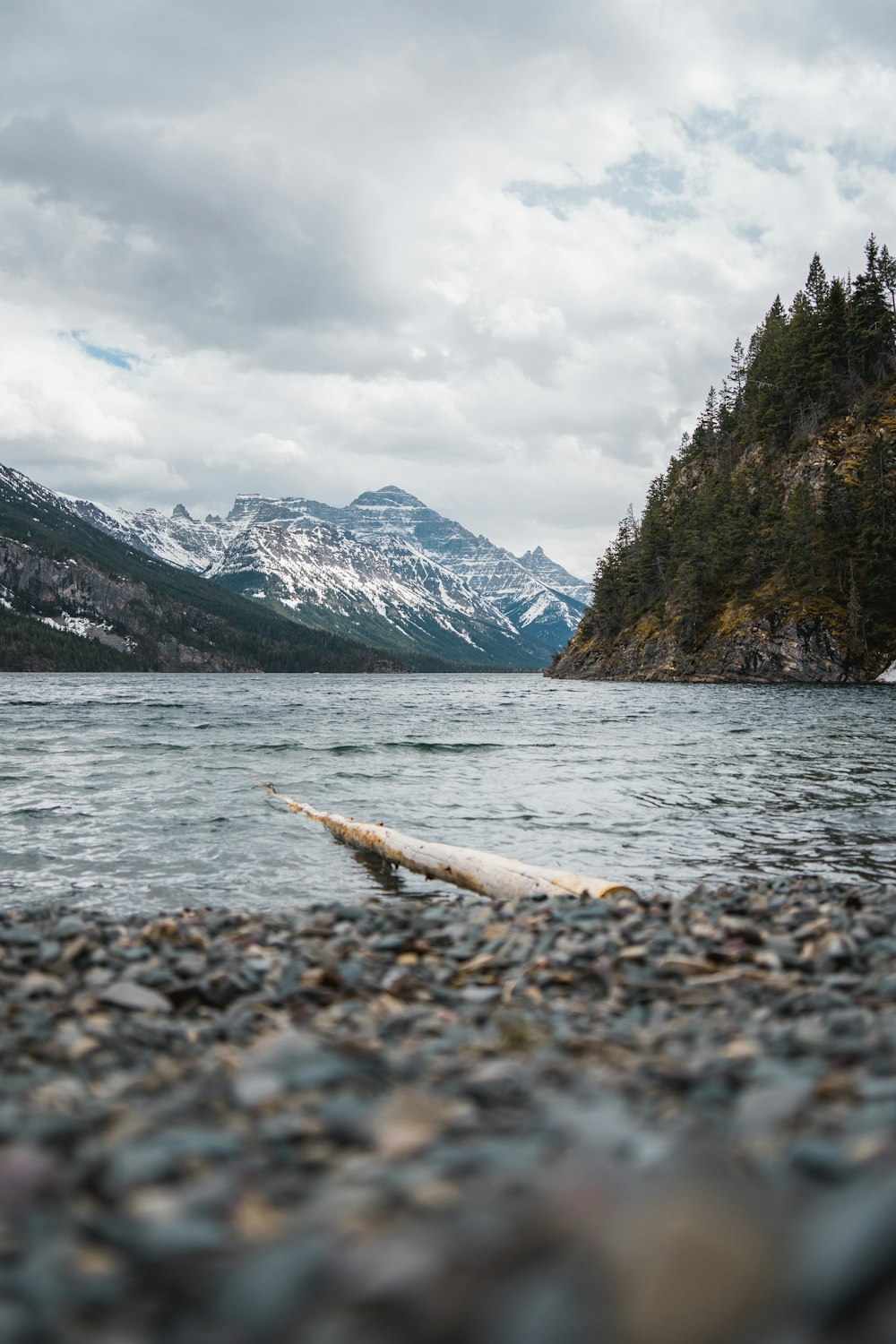 snow covered mountain near body of water during daytime