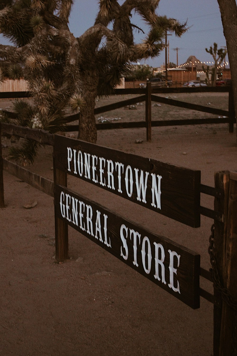 brown wooden signage near green tree during daytime