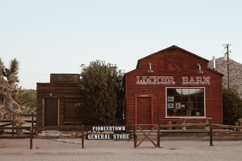 red wooden building near green trees during daytime