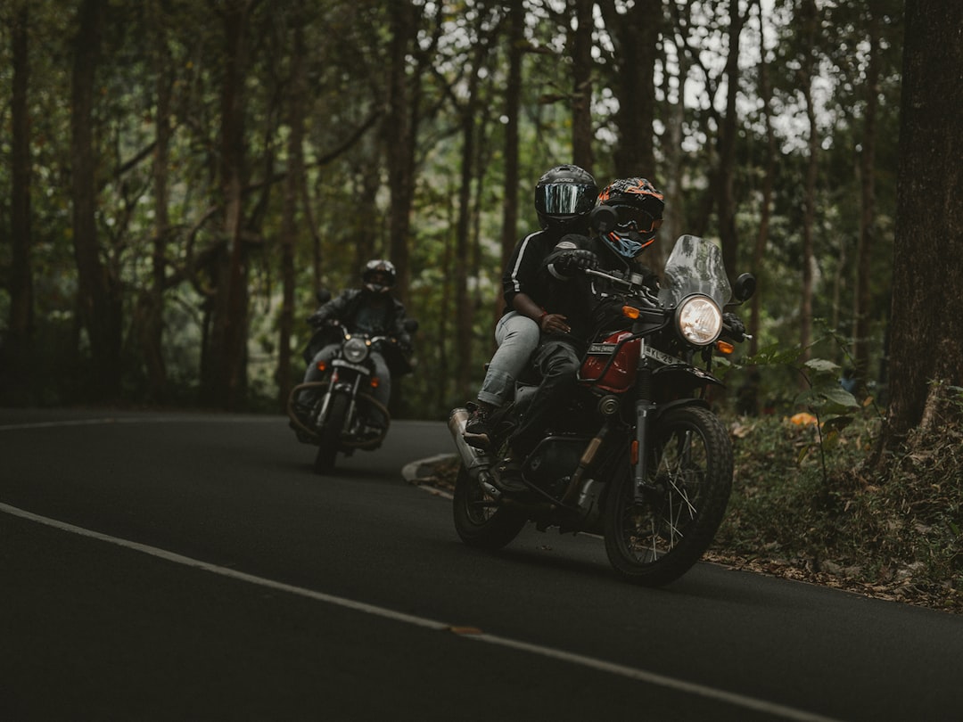 2 men riding motorcycle on road during daytime