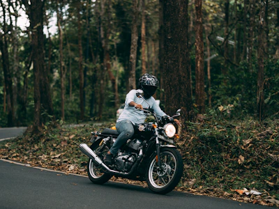 man in white shirt riding black motorcycle on road during daytime