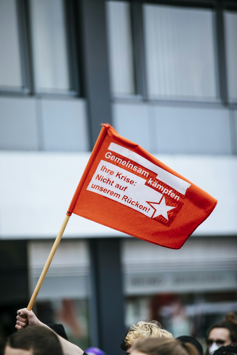 a person holding a red flag in a crowd