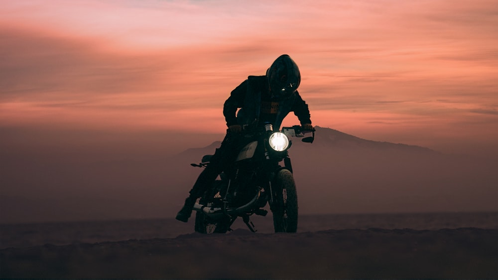 silhouette of man riding motorcycle during sunset