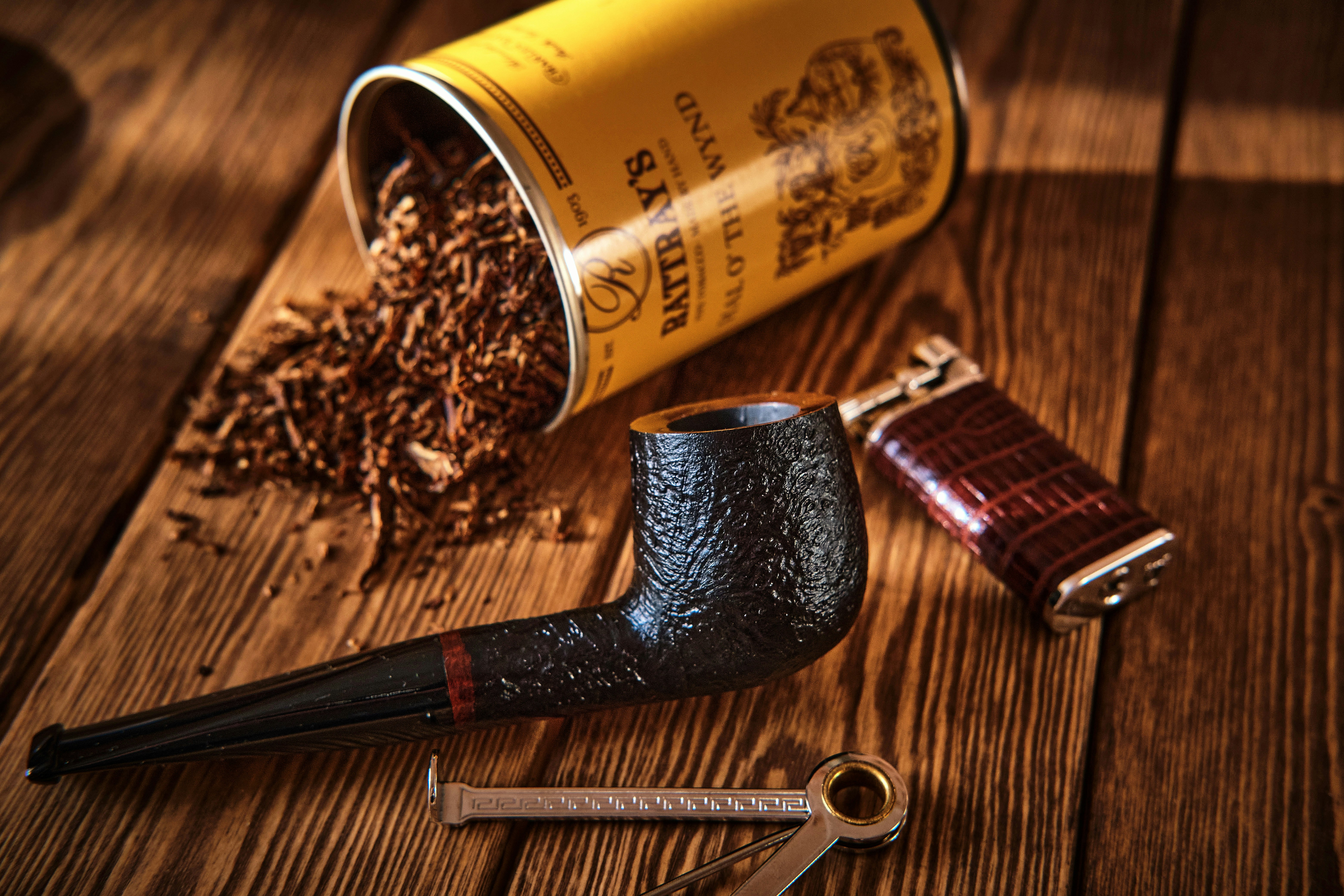 Still life with a smoking pipe, tobacco, lighter and tamper.</p>
<p>” style=”max-width:420px;float:left;padding:10px 10px 10px 0px;border:0px;”>Allerdings ist das gelegentliche Auskratzen ja schön und gut, wenn man einfach nur eine Pfeife im Wechsel raucht – aber was ist, wenn sich der Rußbelag festsetzt und man möchte, dass die Pfeife in Bestform ist? Geschützt, sauber, mit einer glatten, perfekt getrimmten 1,5-mm-Kohleschicht. Ich habe drei verschiedene Methoden durchgespielt, um herauszufinden, wie man unseren Lieblings-Briarpfeifen gerecht wird – von der grundlegenden Pflege bis hin zum Umgang mit einer versteinerten Katastrophe.</p>
<p><img decoding=