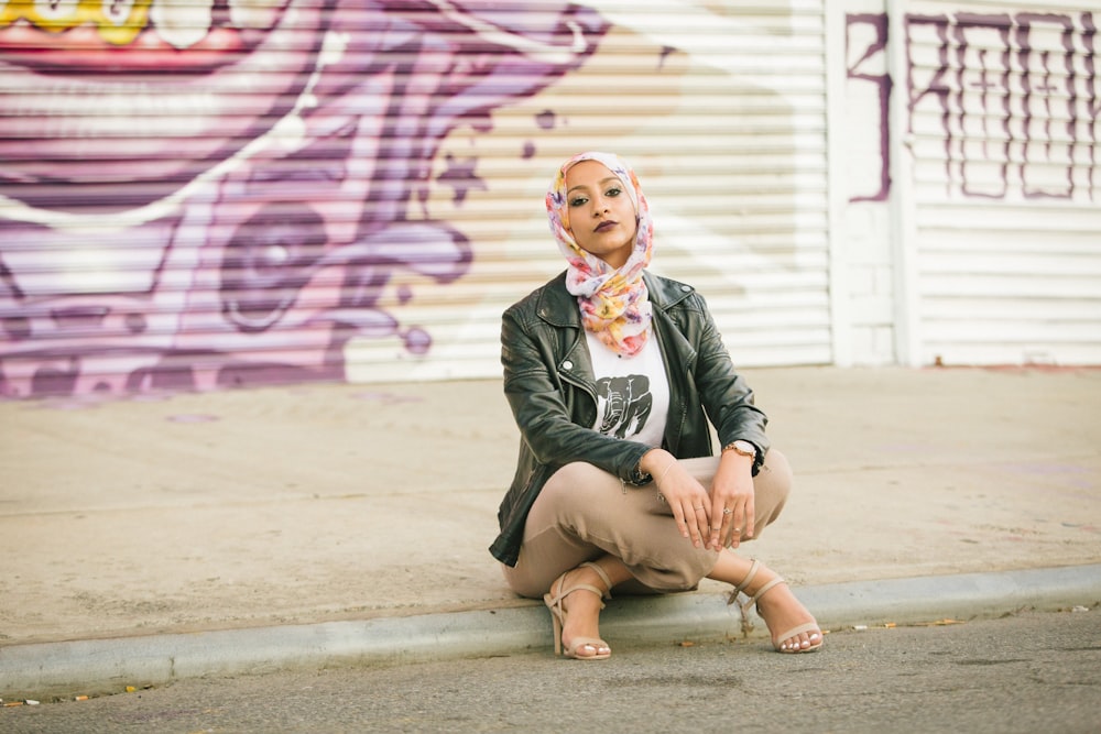 woman in black blazer sitting on the road