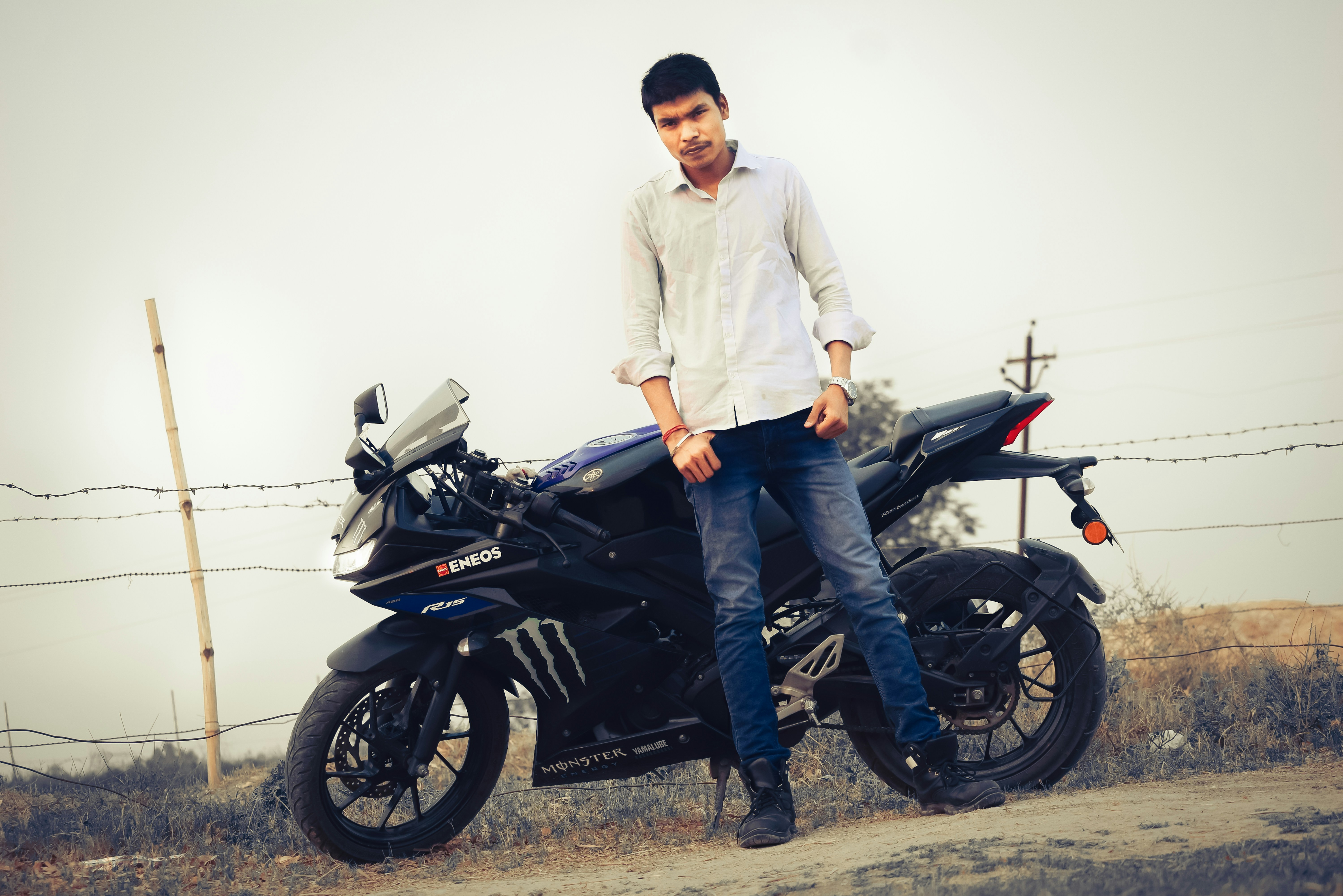 Young man with casual confident smile, light stubble, outdoor portrait, relaxed biker energy